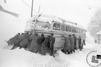 As there was no other way, the passengers went all out to push the bus out of the snowdrift, Škofja Loka, Škofja Loka, 23 January 1958. <em>Foto: Edi Šelhaus, the original negative is kept by the National Museum of Contemporary History. </em>